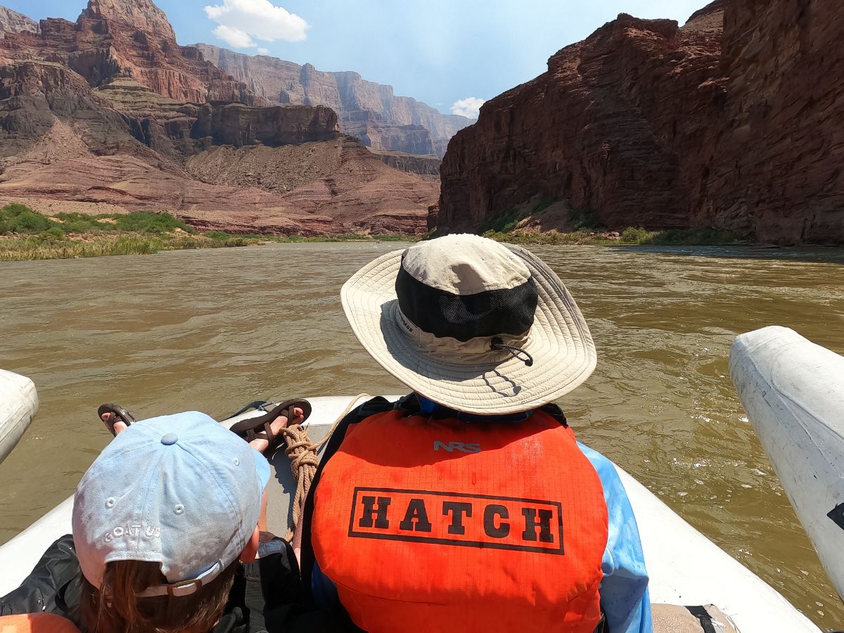 river trip guest on the front of a motorized raft heading down the colorado river