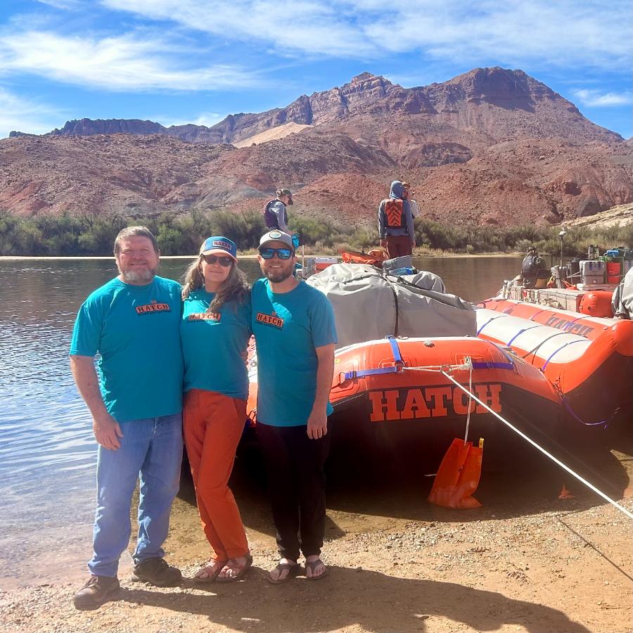 people next to rafts at lees ferry arizona along colorado river wearing t-shirts celebrating 90 years in grand canyon
