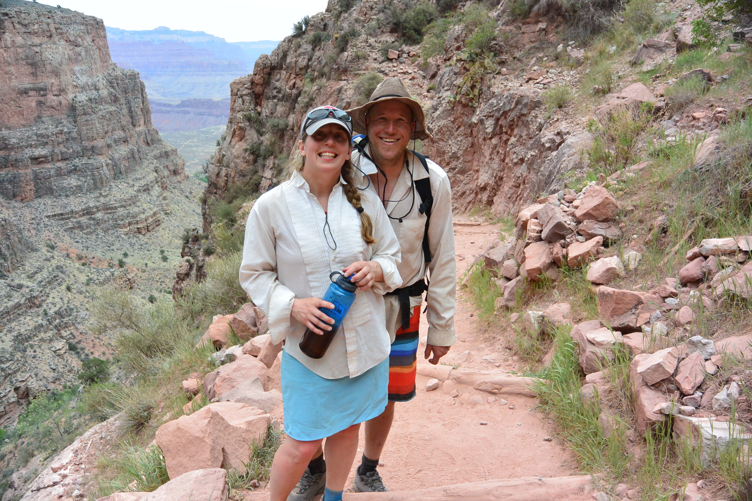 A couple posing on the Bright Angel Trail with the Grand Canyon behind them. Photo credit: Morris Outwater.