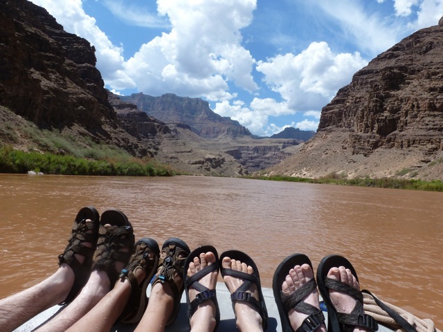 Feet in sandals on the front of a raft in Grand Canyon. River sandals reviewed by a Hatch river guide.