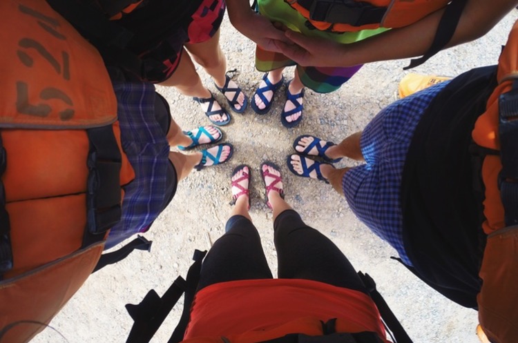 A top down view of people wearing Chaco sandals on a beach in Grand Canyon. Photo credit: Sydney Gordon. 