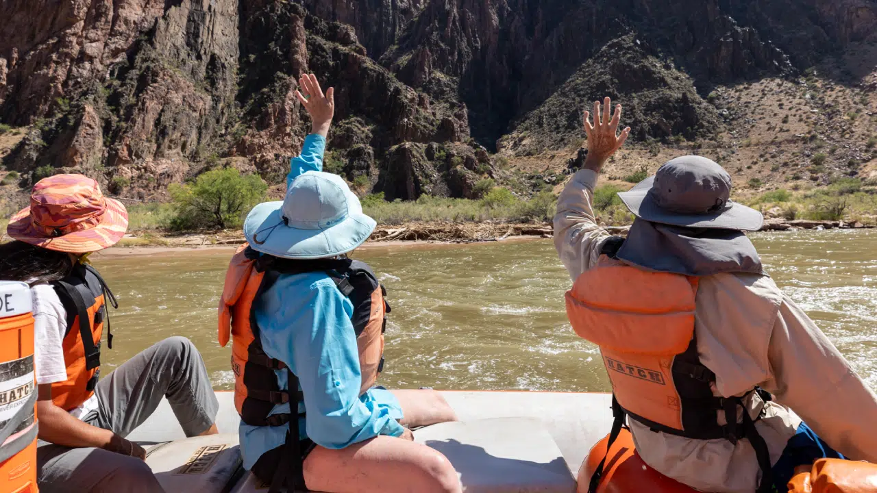 People on boat waving on 4 day trip of lower grand canyon