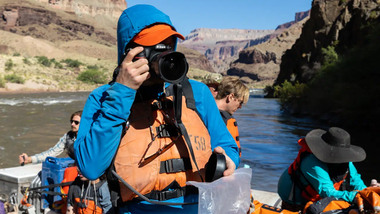 person taking photo with colorado River in the background on 4 day lower grand canyon trip by hatch river expeditions