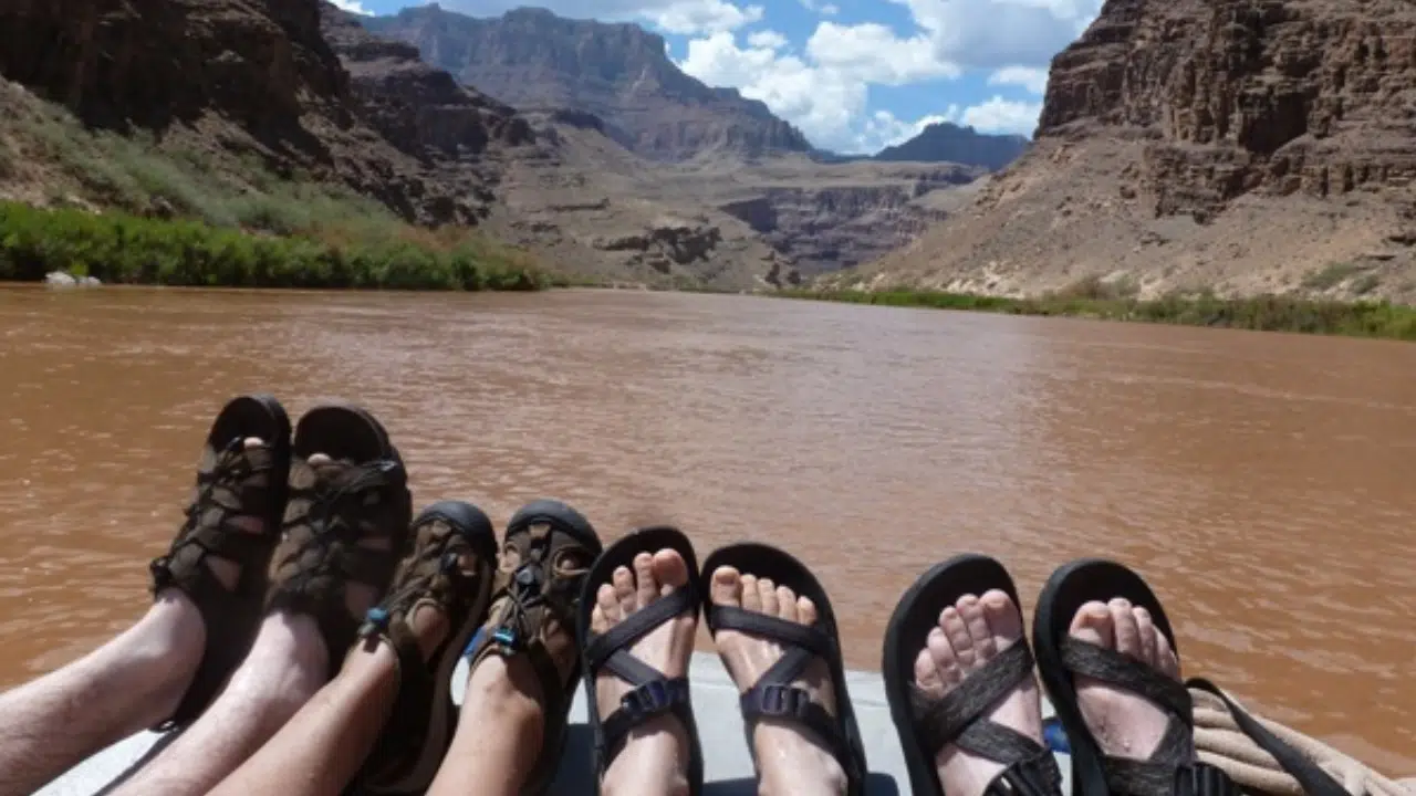 Person relaxing with feet up on motorized boat of Hatch River Expeditions Loewr Canyon Motorized Trip