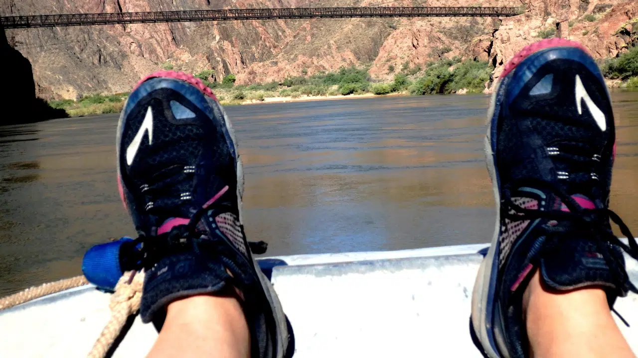 Person relaxing with feet showing from boat while on Colorado River trip with Hatch River Expeditions