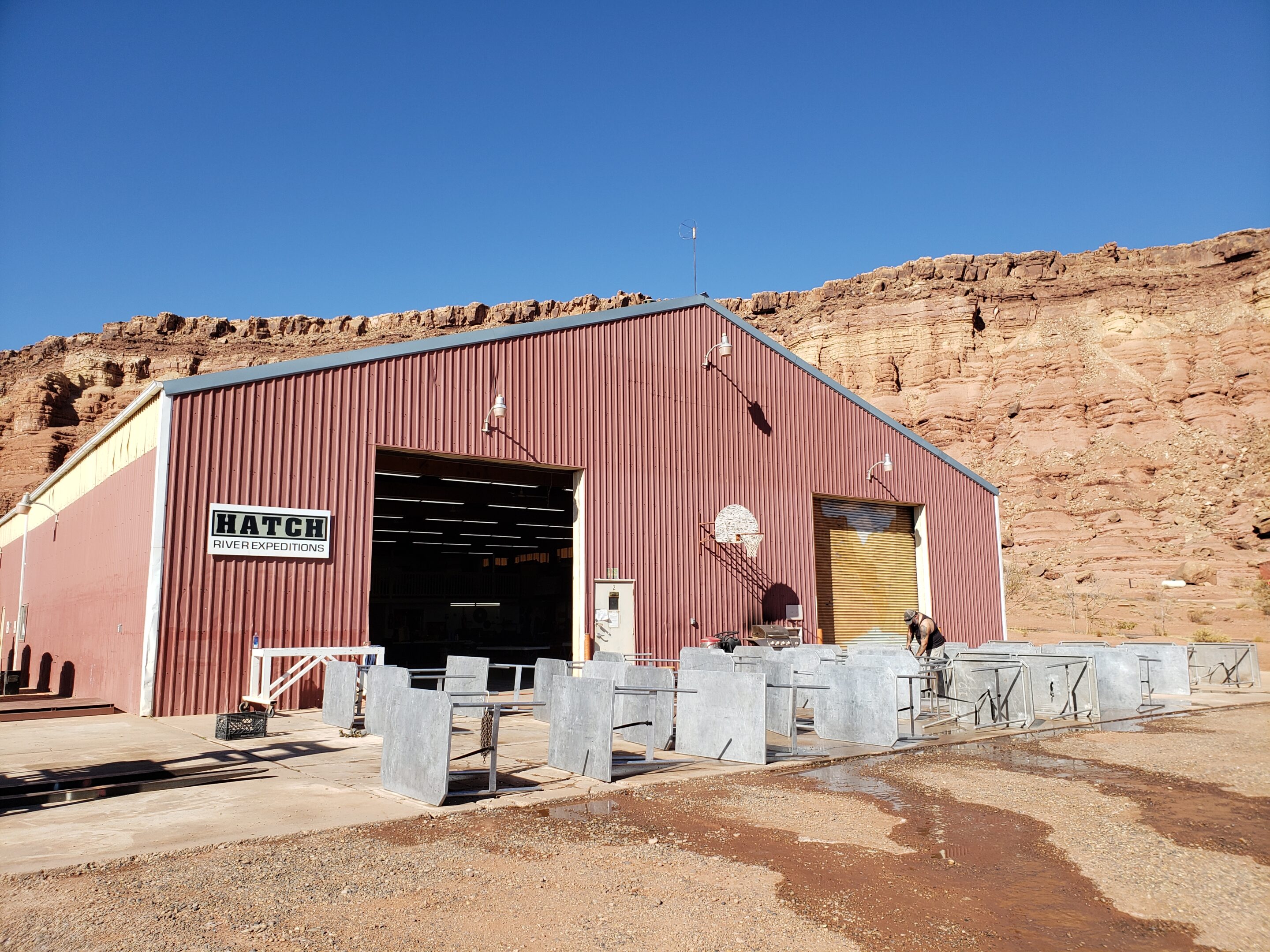 Pressure washing kitchen tables in front of the Hatch River Expeditions warehouse for winter work during the river rafting off season