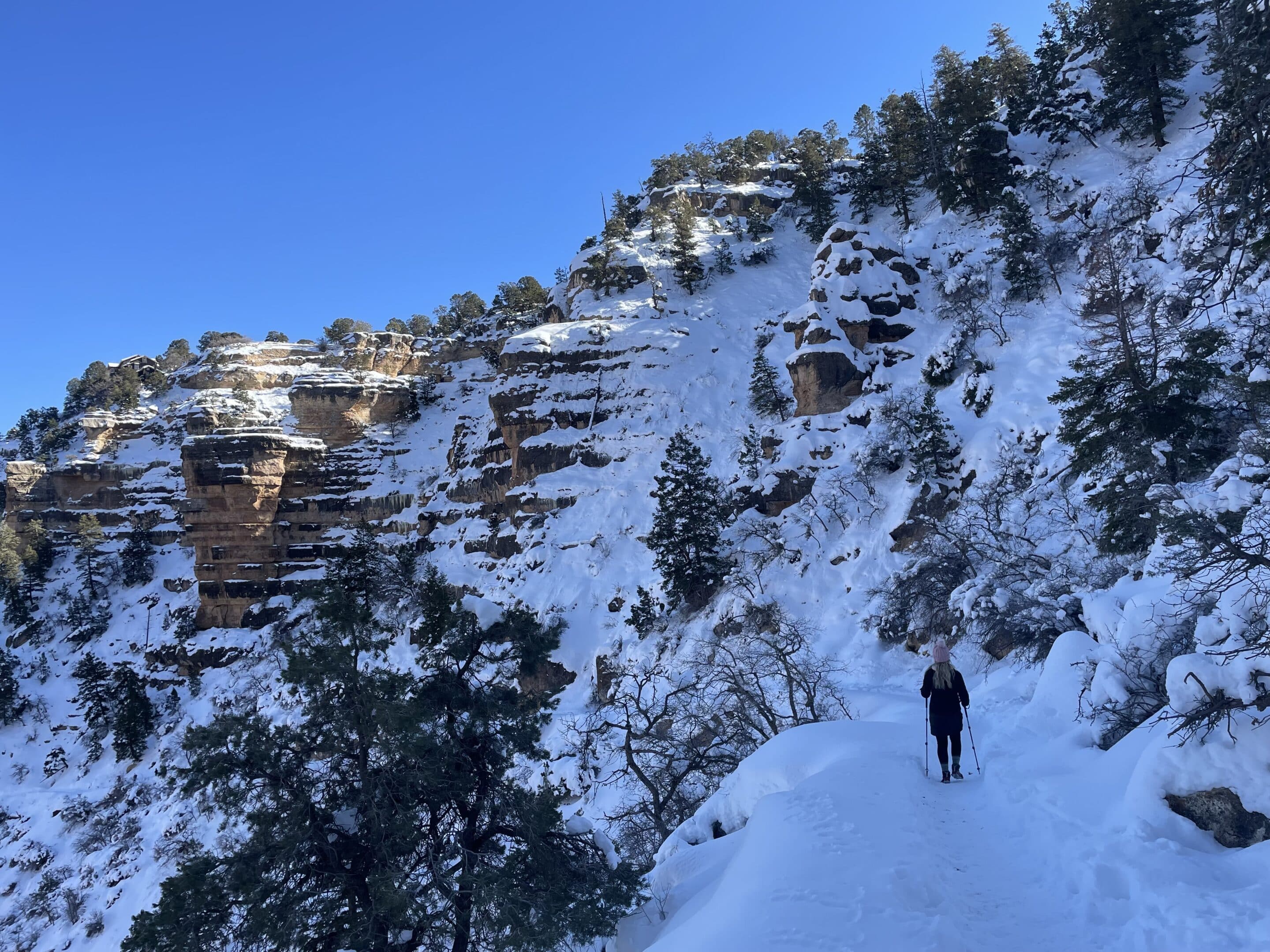 Woman hiking snow covered Bright Angel Trail in Grand Canyon in winter