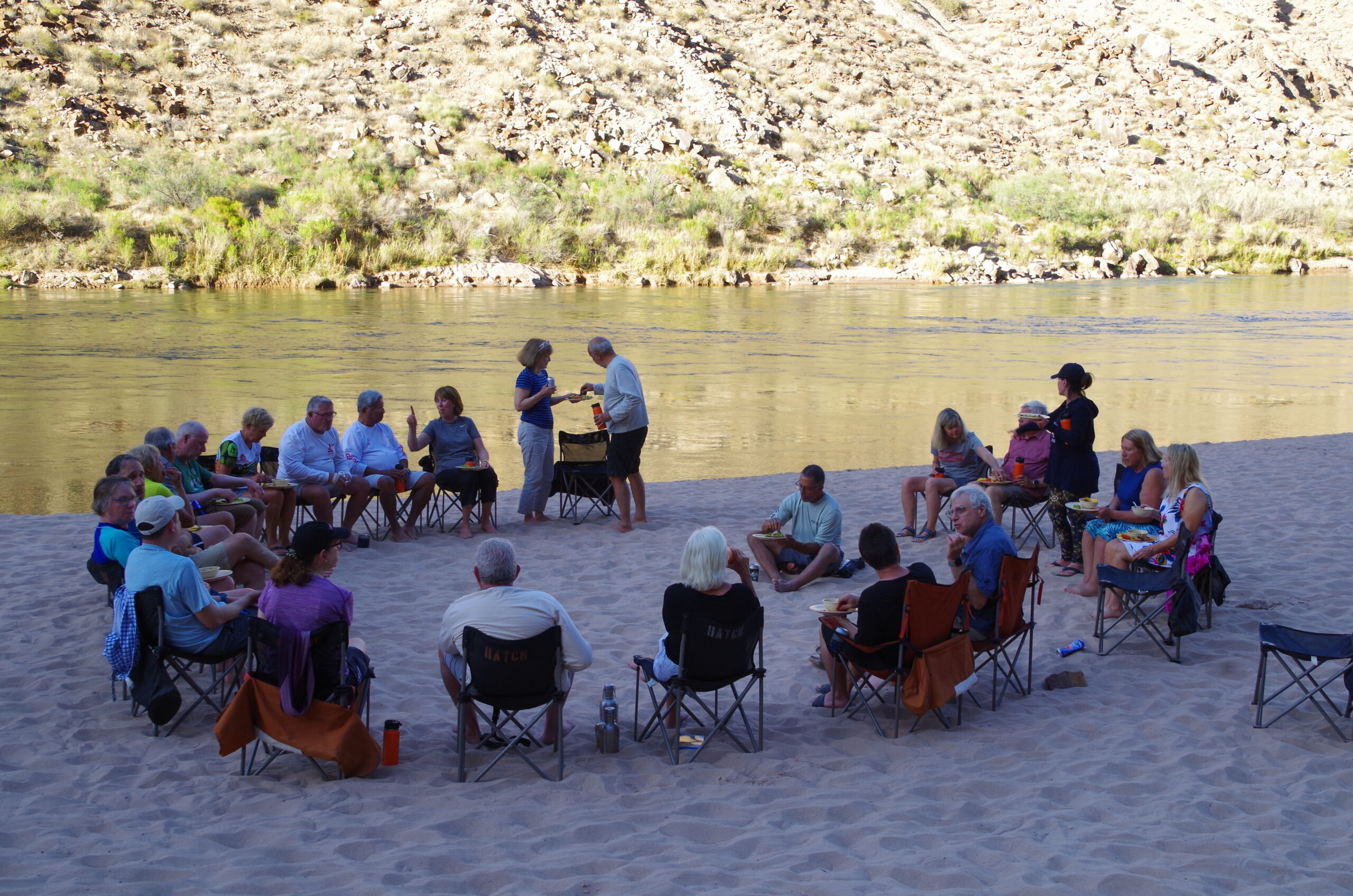 People sit in a chair circle on the beach along the Colorado River running though Grand Canyon National Park. 4 types of people you'll meet on a Grand Canyon river trip with Hatch River Expeditions.