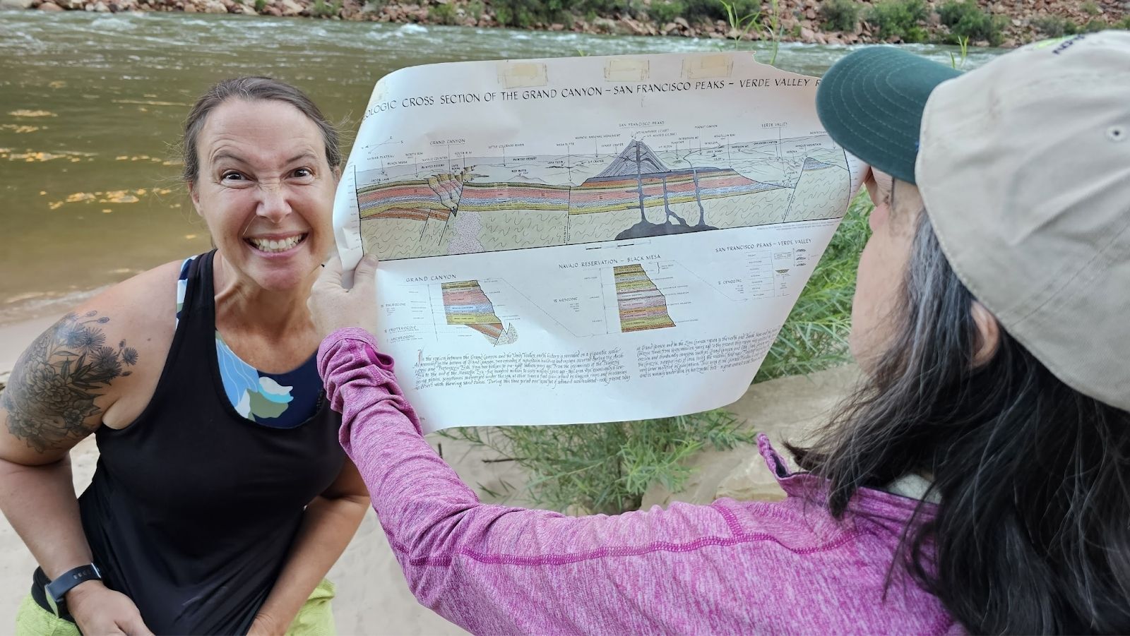 Two women review a geologic cross-section map during a Hatch River Expeditions trip.