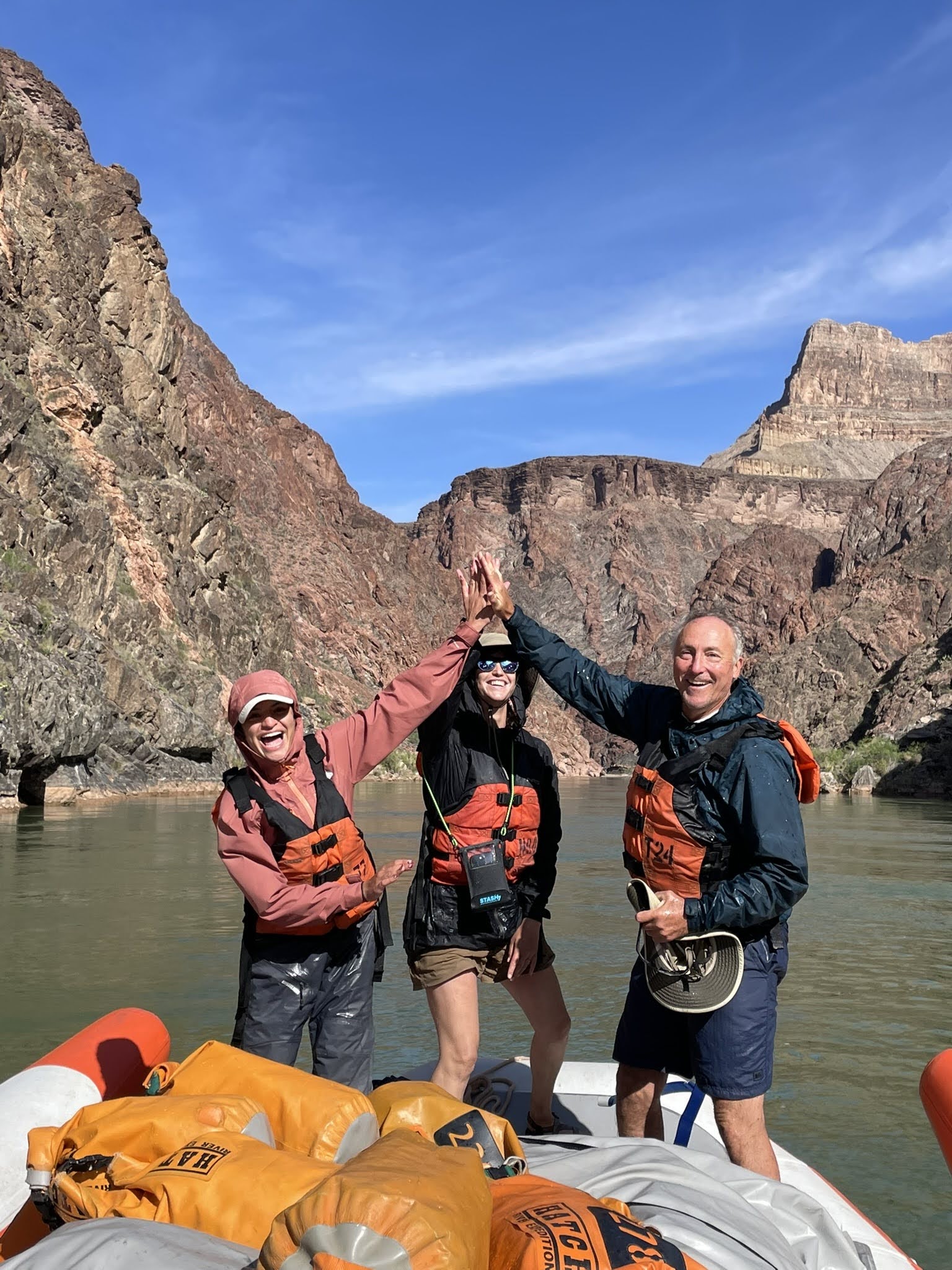 Hatch guests high fiving on the river.