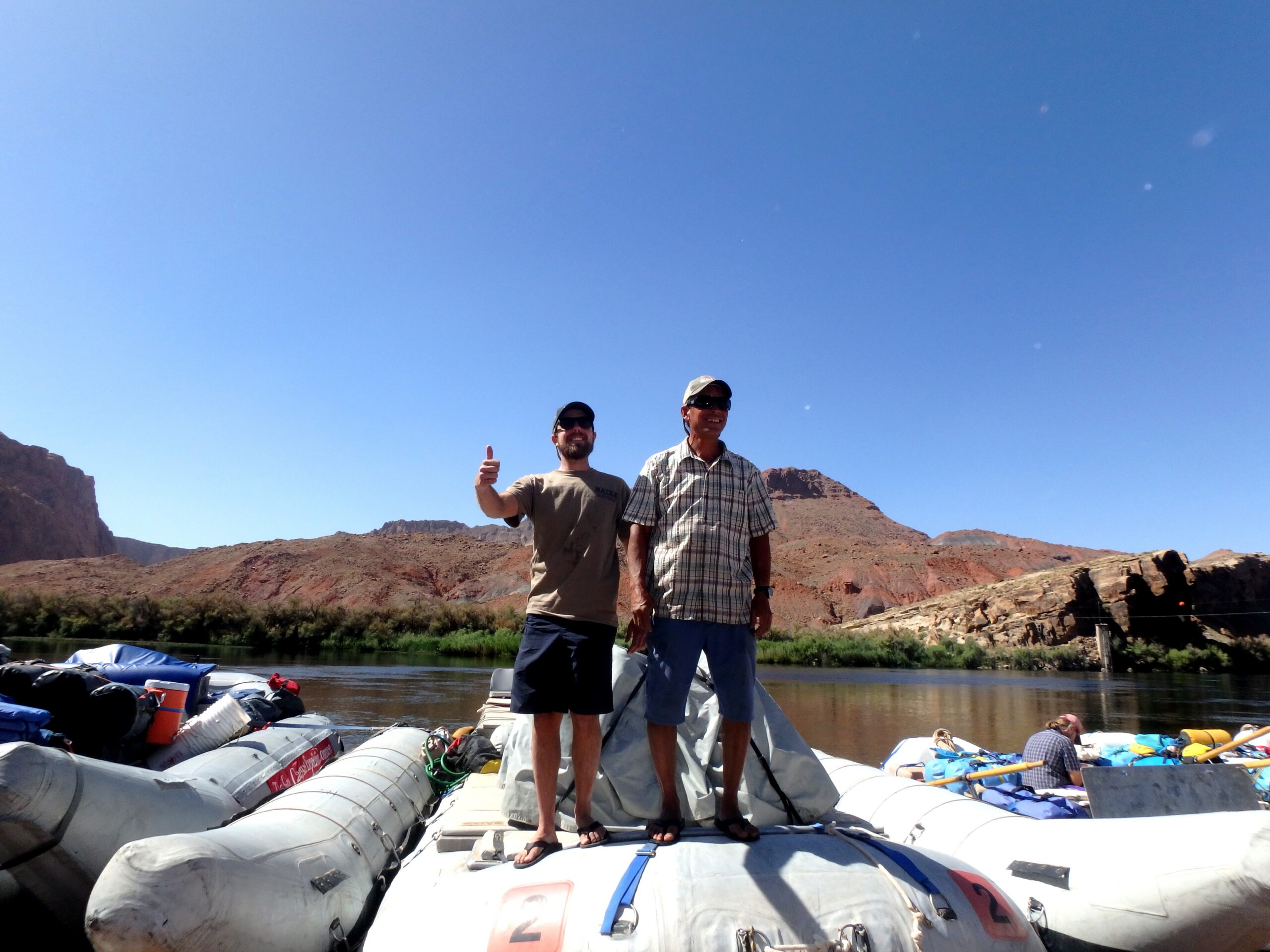 Two Hatch guides stand on top of a raft to give an orientation to guests after they get to Lees Ferry. Photo credit: Melissa Yates.